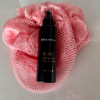 Bellanomi Glow Body Oil bottle on a pink mesh background